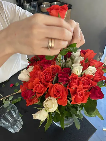 Female hands make a bouquet of red and white small roses. High quality photo