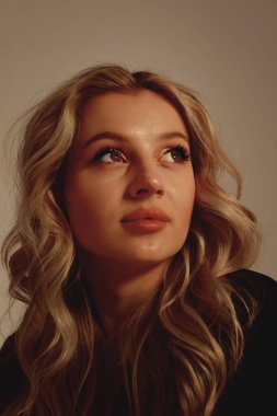 Uzun saçlı ve hoş görünümlü güzel bir sarışının portresi.