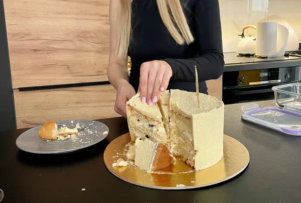 Female hands cut off a piece of festive cake with a knife. High quality photo