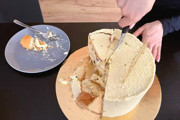 Female hands cut off a piece of festive cake with a knife. High quality photo