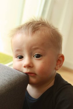 Siyah gözlü, düşüncelere dalmış sevimli bir çocuğun portresi.