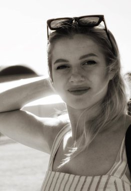 Güneşin altında güzel bir genç kadının siyah beyaz portresi.