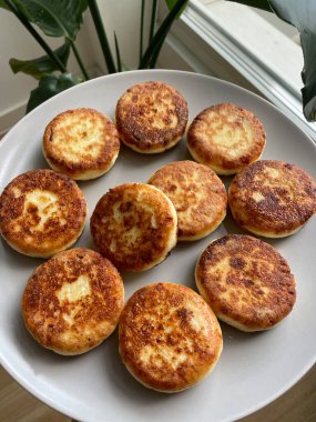 Kızarmış, kahverengi peynirli kekler gri bir kasede hazırlanır. Yüksek kalite fotoğraf