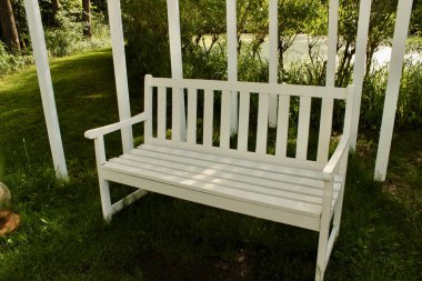 Parkta kemerli beyaz bir ahşap salıncak var. Yüksek kalite fotoğraf