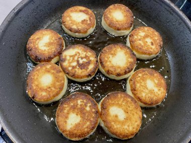 Yuvarlak tatlı peynirli kekler kahvaltıda tavada kızartılır. Yüksek kalite fotoğraf