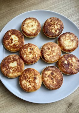 Kızarmış, kahverengi peynirli kekler gri bir kasede hazırlanır. Yüksek kalite fotoğraf