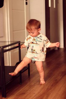 Küçük bir çocuk evde tek başına oynuyor.