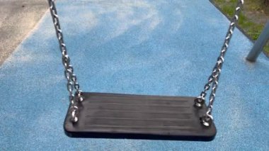 Boş bir zincir salıncak parkta tek başına sallanıyor.