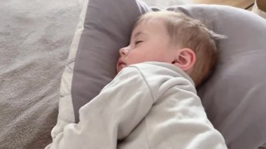 Küçük bir çocuk yastıkta uyuyor, uykulu bir bebek sallanıyor..