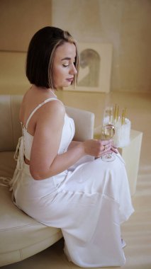 Doğum günü kızı, şenlikli kıyafetli güzel bir kadın bir kadeh şampanyayla poz veriyor