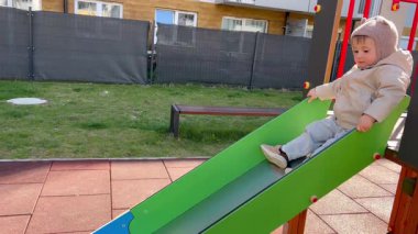 Bir çocuk oyun parkında kayıyor.