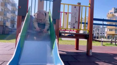 Küçük bir çocuk midesinde kayar, küçük bir çocuk oyun alanında oynar.