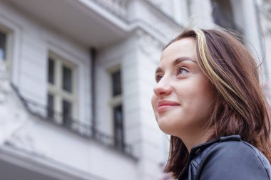 Beyaz, eski bir mimarinin arka planında çekici, esmer bir kadının portresi.