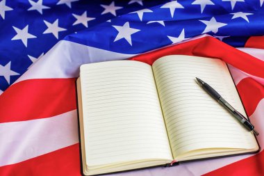 Amerikan bayrağı arka planında metin ve kalem için boş sayfaları olan açık bir defter