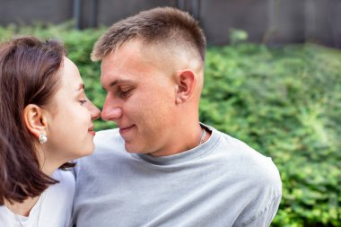 Parkta buluşan mutlu genç çift, dışarıda birlikte vakit geçirirken neşeyle konuşuyor ve birbirlerine hayranlık duyuyorlar. Yüksek kalite fotoğraf