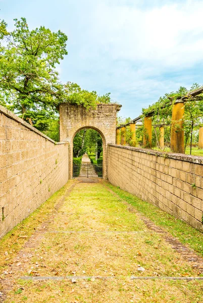 The descent between the stone walls to the park gates in the form of an arch.Vertical photo