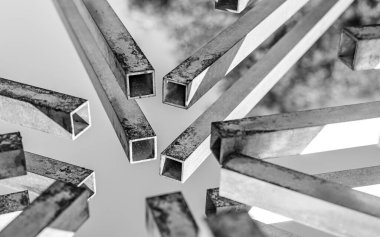 Birkaç paslı kare borunun uçları bir noktada birleşiyor. İki borunun sonlarına odaklan. Soyutlama. Siyah beyaz fotoğraf