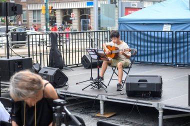 Toronto, ON, Kanada - 17 Ağustos 2024: Toronto Çin Mahallesi Festivali 'nde genç bir gitarist sahne aldı.
