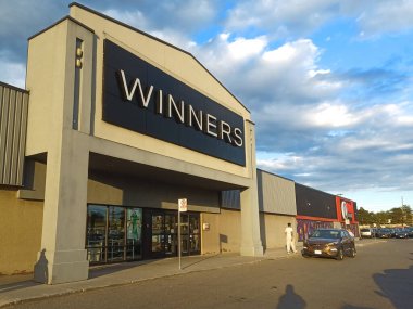 Toronto, ON, Canada - February 26, 2024: View at the brand identity sign over the entrance of a Winners discount fashion store in a shopping mall in Toronto clipart