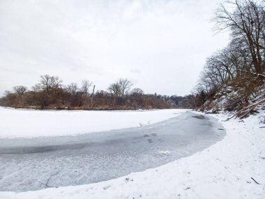 Kışın kıyıdan gelen buzla kaplı nehir manzarası