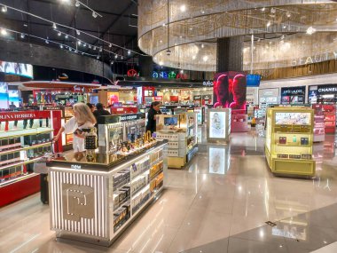 Cancun, Quintana Roo, Meksika 26 Kasım 2024: Gezginler Cancun Uluslararası Havalimanı vergisiz mağazasında renkli tekila vitrinlerine ve hediyelere göz atıyor..