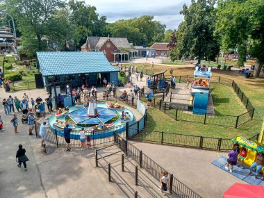 Toronto, ON, Kanada 08 Ağustos 2024: Çocuklar Centerville Lunaparkı 'nda küçük motorlu teknelere binerken ebeveynler de yakınlarda seyrediyorlar...