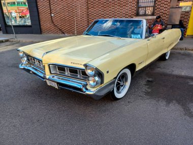 Toronto, ON, Kanada 08 Eylül 2024: Klasik bir Pontiac Parisienne üstü açık araba, insanların bir sokak etkinliği sırasında hayranlıkla izlediği gibi dükkanların önüne park ediyor..