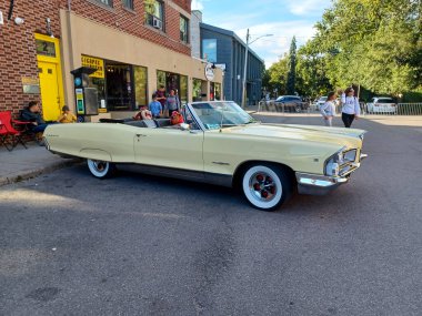 Toronto, ON, Kanada 08 Eylül 2024: Klasik bir Pontiac Parisienne üstü açık araba, insanların bir sokak etkinliği sırasında hayranlıkla izlediği gibi dükkanların önüne park ediyor..