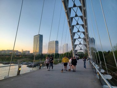 Toronto, ON, Kanada 11 Temmuz 2024: İkonik Humber Körfezi Kemer Köprüsü arkaplanda yüksek binalar bulunan arkaplanda parçalı bulutlu bir gökyüzü altında nehir boyunca uzanır..