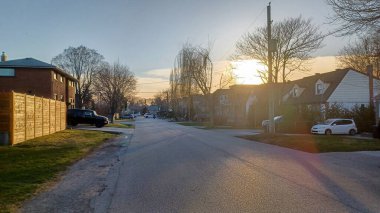 Toronto, ON, Kanada - 9 Nisan 2025: Park halindeki arabaların ve olgun ağaçların tomurcuklanmaya başladığı sakin bir yerleşim yeri..