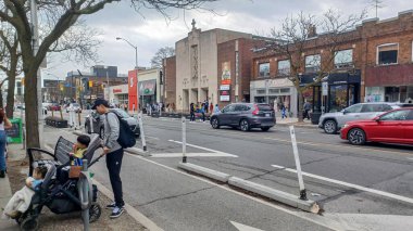 Toronto, ON, Kanada - 14 Nisan 2025: İnsanlar Durie Caddesi yakınlarındaki Bloor Caddesi boyunca 9 bahar öğleden sonra bulutlu bir gökyüzü altında yürüyüp alışveriş yapıyorlar.