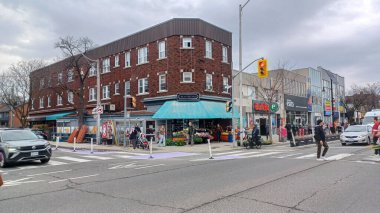 Toronto, ON, Kanada - 14 Nisan 2025: İnsanlar Durie Caddesi yakınlarındaki Bloor Caddesi boyunca 9 bahar öğleden sonra bulutlu bir gökyüzü altında yürüyüp alışveriş yapıyorlar.