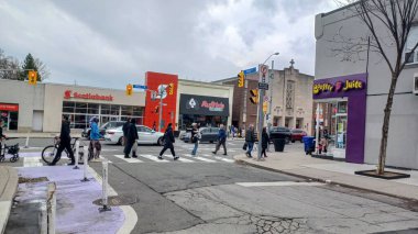 Toronto, ON, Kanada - 14 Nisan 2025: İnsanlar Durie Caddesi yakınlarındaki Bloor Caddesi boyunca 9 bahar öğleden sonra bulutlu bir gökyüzü altında yürüyüp alışveriş yapıyorlar.