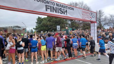 Toronto, ON, Kanada - 29 Nisan 2025: Toronto Maratonu bitiş çizgisinde büyük bir koşucu grubu toplanıyor. Çok sayıda koşucu ve dar yol geçişi imkansız kılıyor..