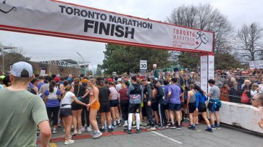 Toronto, ON, Kanada - 29 Nisan 2025: Toronto Maratonu bitiş çizgisinde büyük bir koşucu grubu toplanıyor. Çok sayıda koşucu ve dar yol geçişi imkansız kılıyor..