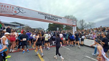 Toronto, ON, Kanada - 29 Nisan 2025: Toronto Maratonu bitiş çizgisinde büyük bir koşucu grubu toplanıyor. Çok sayıda koşucu ve dar yol geçişi imkansız kılıyor..