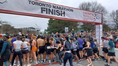 Toronto, ON, Kanada - 29 Nisan 2025: Toronto Maratonu bitiş çizgisinde büyük bir koşucu grubu toplanıyor. Çok sayıda koşucu ve dar yol geçişi imkansız kılıyor..