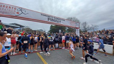 Toronto, ON, Kanada - 29 Nisan 2025: Toronto Maratonu bitiş çizgisinde büyük bir koşucu grubu toplanıyor. Çok sayıda koşucu ve dar yol geçişi imkansız kılıyor..