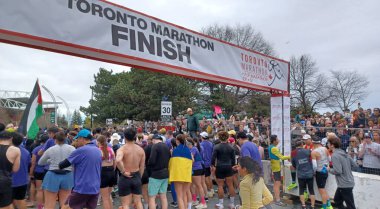 Toronto, ON, Kanada - 29 Nisan 2025: Toronto Maratonu bitiş çizgisinde büyük bir koşucu grubu toplanıyor. Çok sayıda koşucu ve dar yol geçişi imkansız kılıyor..