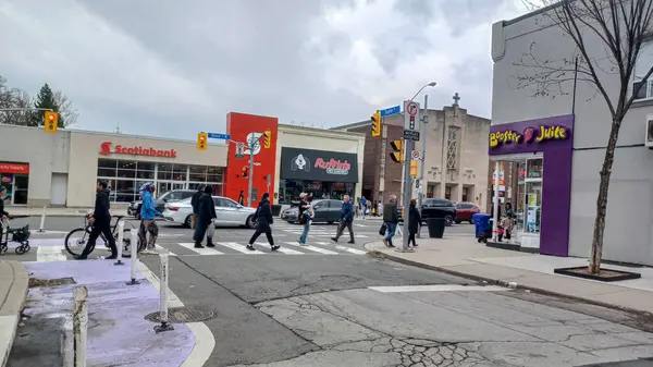 Toronto, ON, Kanada - 14 Nisan 2025: İnsanlar Durie Caddesi yakınlarındaki Bloor Caddesi boyunca 9 bahar öğleden sonra bulutlu bir gökyüzü altında yürüyüp alışveriş yapıyorlar.