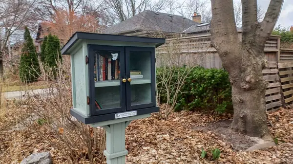 Toronto, ON, Kanada - 13 Nisan 2025: Bir yerleşim bölgesindeki kaldırım kenarında beyaz bir Serbest Kütüphane duruyor.