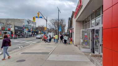 Toronto, ON, Kanada - 14 Nisan 2025: İnsanlar Durie Caddesi yakınlarındaki Bloor Caddesi boyunca 9 bahar öğleden sonra bulutlu bir gökyüzü altında yürüyüp alışveriş yapıyorlar.