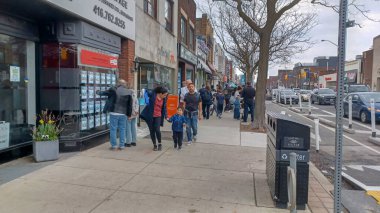 Toronto, ON, Kanada - 14 Nisan 2025: İnsanlar Durie Caddesi yakınlarındaki Bloor Caddesi boyunca 9 bahar öğleden sonra bulutlu bir gökyüzü altında yürüyüp alışveriş yapıyorlar.