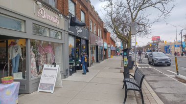 Toronto, ON, Kanada - 14 Nisan 2025: İnsanlar Durie Caddesi yakınlarındaki Bloor Caddesi boyunca 9 bahar öğleden sonra bulutlu bir gökyüzü altında yürüyüp alışveriş yapıyorlar.