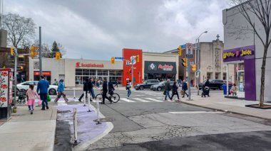 Toronto, ON, Kanada - 14 Nisan 2025: İnsanlar Durie Caddesi yakınlarındaki Bloor Caddesi boyunca 9 bahar öğleden sonra bulutlu bir gökyüzü altında yürüyüp alışveriş yapıyorlar.