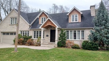 Toronto, ON, Kanada - 13 Nisan 2025: Bulutlu bir günde Etobikola bölgesinde yan yana duran iki farklı mesken.