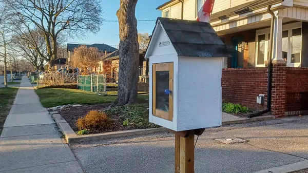 Toronto, ON, Kanada - 13 Nisan 2025: Bir yerleşim bölgesindeki kaldırım kenarında beyaz bir Serbest Kütüphane duruyor.