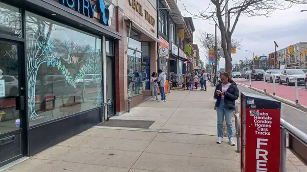 Toronto, ON, Kanada - 14 Nisan 2025: İnsanlar Durie Caddesi yakınlarındaki Bloor Caddesi boyunca 9 bahar öğleden sonra bulutlu bir gökyüzü altında yürüyüp alışveriş yapıyorlar.