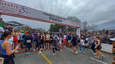 Toronto, ON, Kanada - 29 Nisan 2025: Toronto Maratonu bitiş çizgisinde büyük bir koşucu grubu toplanıyor. Çok sayıda koşucu ve dar yol geçişi imkansız kılıyor..