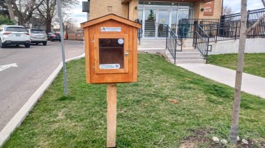 Toronto, ON, Kanada - 13 Nisan 2025: Bir yerleşim bölgesindeki kaldırım kenarında beyaz bir Serbest Kütüphane duruyor.